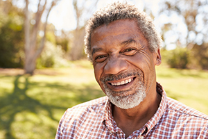 Older man smiling in backyard